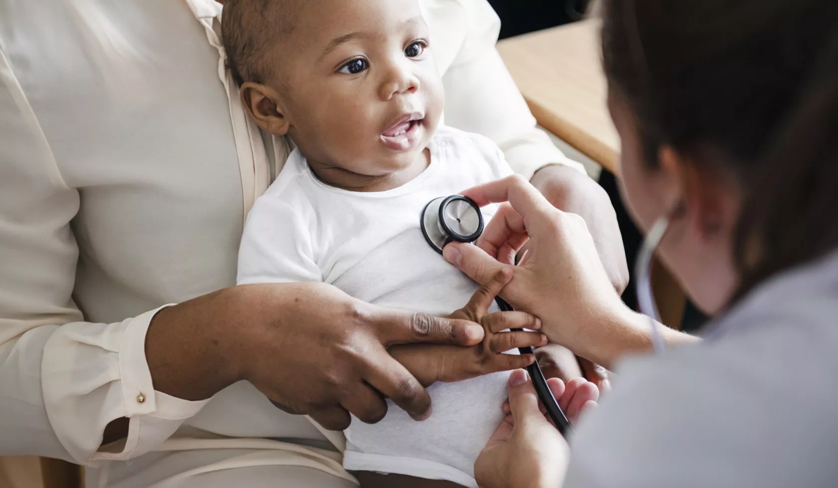 A doctor checks a baby's heartbeat with a stethoscope